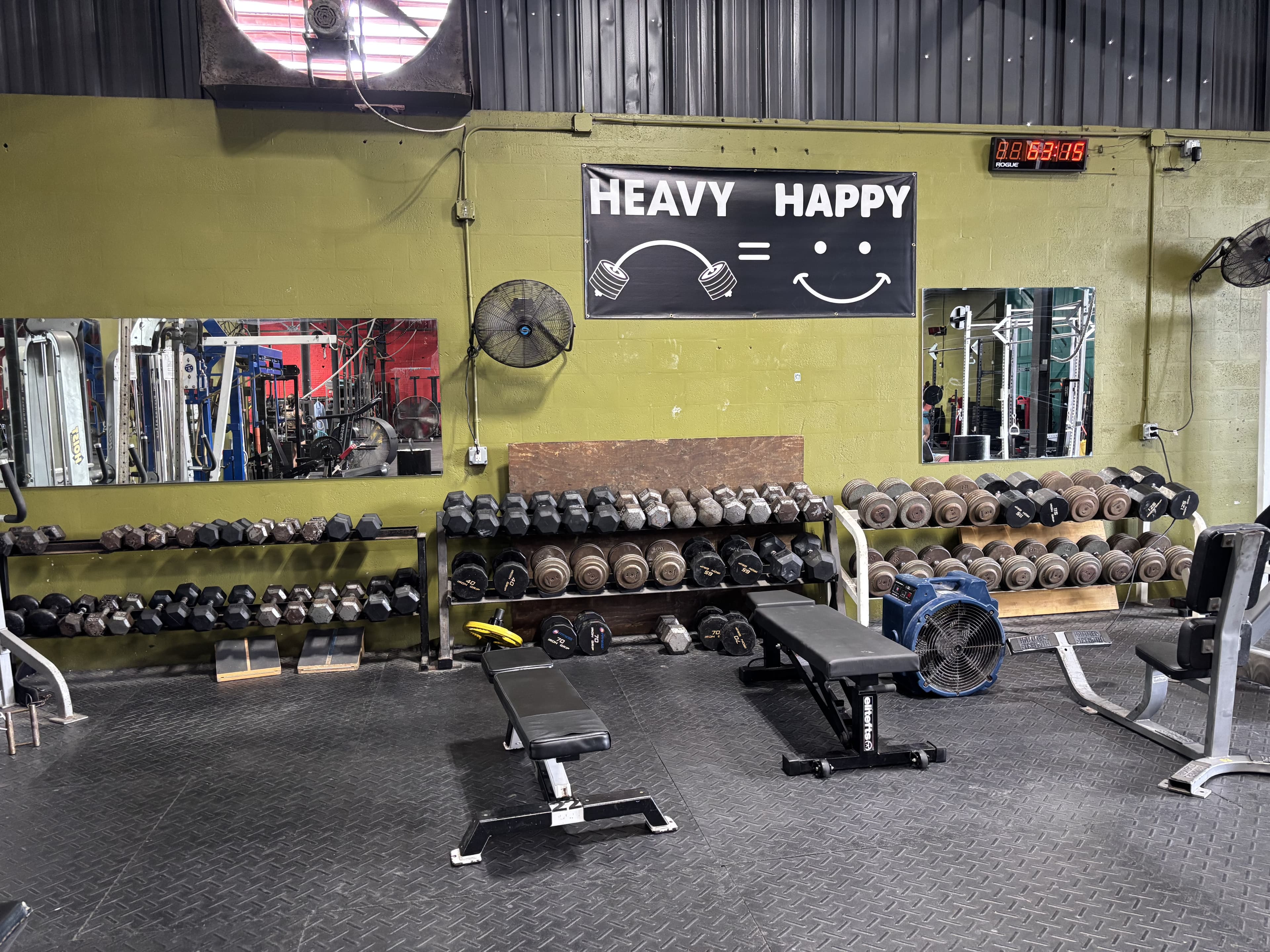 The Heavy Happy sign above the dumbbell racks at Havoc